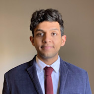 Anas, an international student from Saudi Arabia at the University of South Carolina, smiles at the camera while wearing a suit jacket and tie