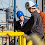 Three international students at LSU wear hard hats while working outside at the PERTT petroleum engineering lab