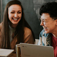 At an internship for students, two female students laugh and talk about how to apply for an internship and how to get an internship during their study abroad program.