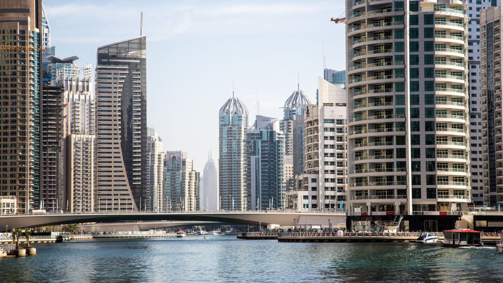 The Dubai skyline towers stand tall above the Dubai Water Canals, not too far from Heriot-Watt University Dubai, a Shorelight university