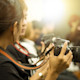 Two international students majoring in journalism at their US university are seen in profile holding professional cameras.