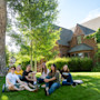 A group of students sit outside on a grassy hill on campus at the University of Wyoming in Laramie, Wyoming