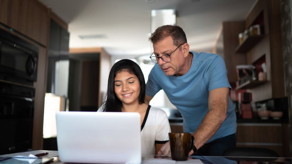 A student and her professor look at her laptop screen to review USA universities, how to study in the USA, the best colleges in America for international students, and international student USA tips.