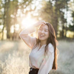 Yang, a student at the University of South Carolina, stands in a field at sunset and laughs for the camera