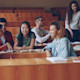 A group of international students sit in a lecture hall at their US university and discuss the new Best Colleges 2026 rankings from U.S. News & World Report.