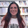 Sarah, an international student from the Czech Republic at Carroll University, stands in front of bookshelves and smiles for the camera.