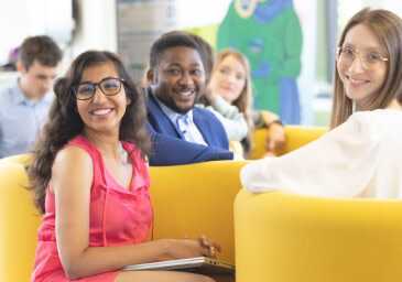 Two women and a man sitting and smiling