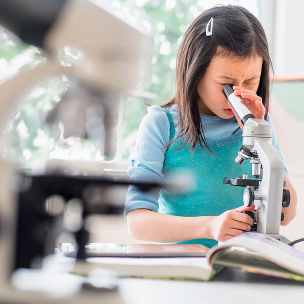 Girl looking through a microscope