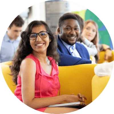 A man and woman sit together and smile at the camera.