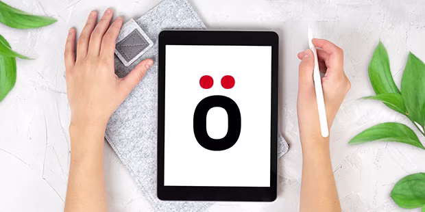 Hände die auf einem refurbished Tablet arbeiten, umgeben von Pflanzen auf hellem Hintergrund