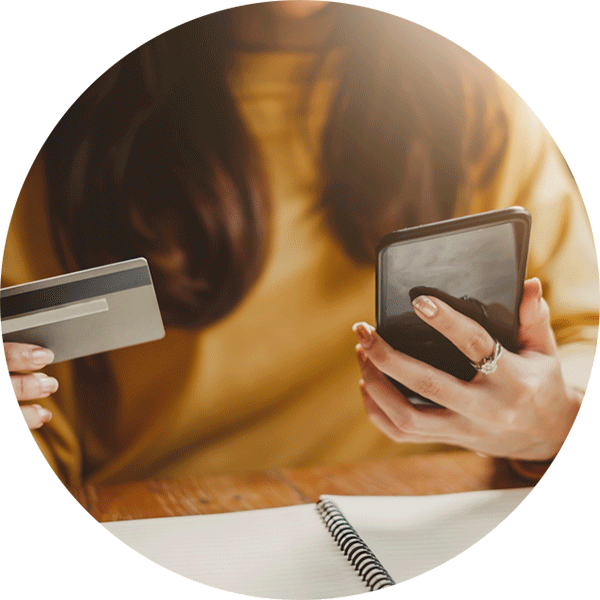 Osoba držící smartphone a bankovní kartu