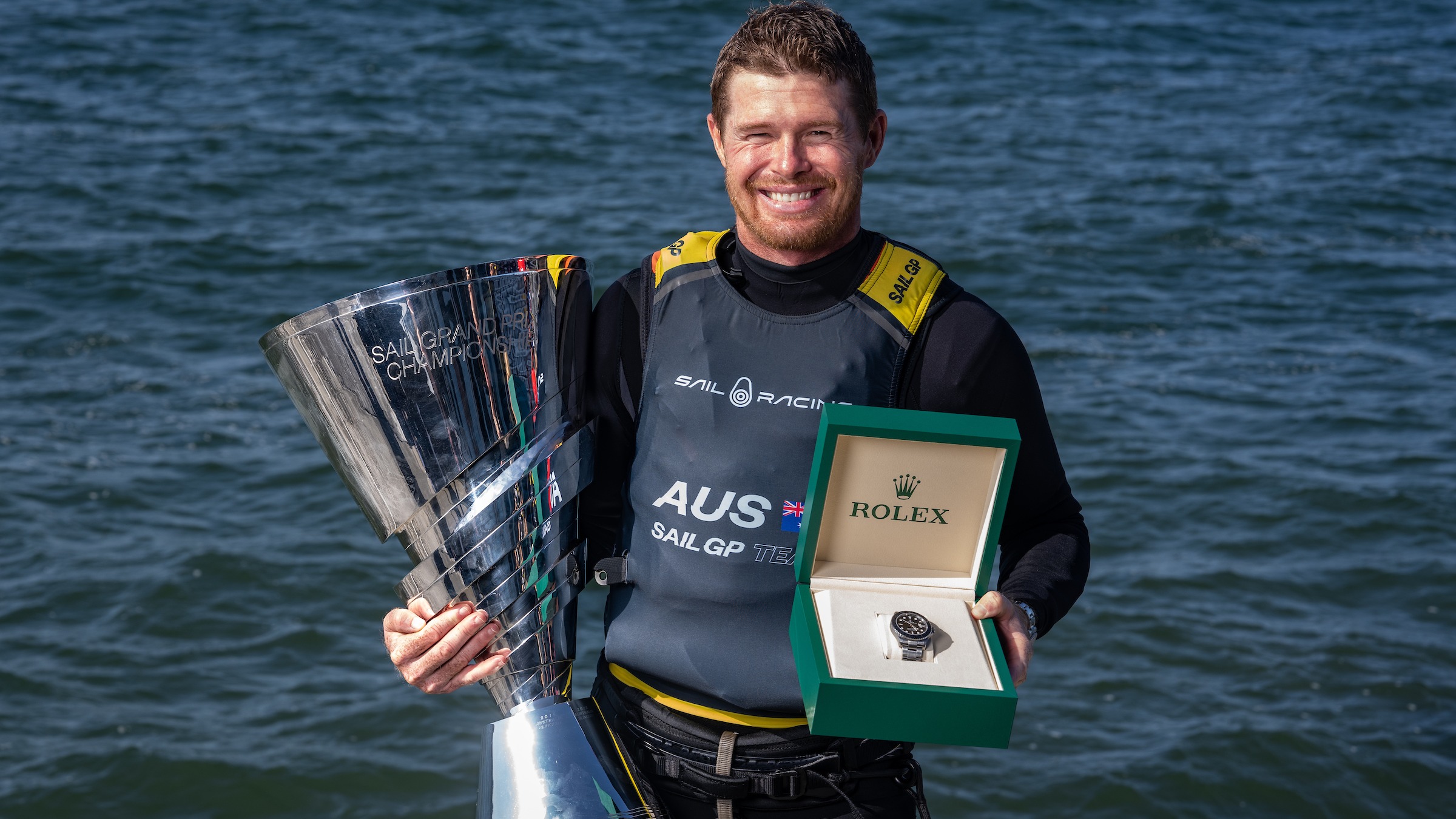 Tom Slingsby poses with SailGP Trophy and Rolex