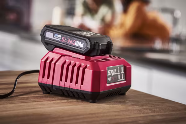Chargeur et batterie SKIL posés sur une table