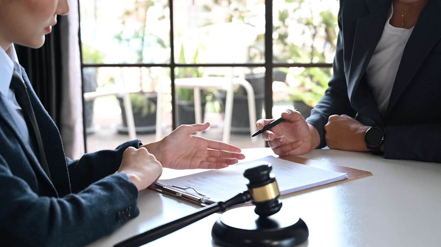Female lawyer explaining terms, condition on legal document to client before signing on contract at law firm. - stock photo