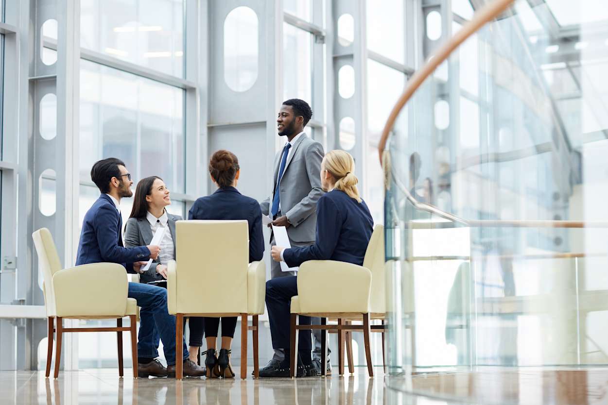Group of professionals sitting in a circle in an office space