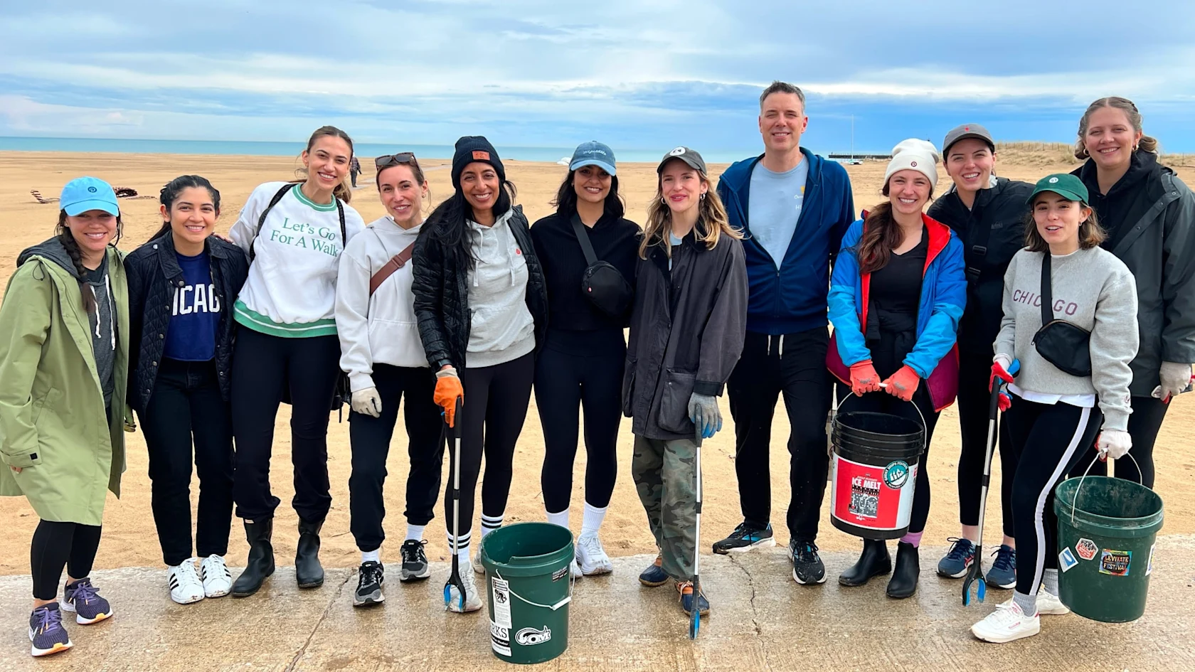 A group of Pinterest employees poses for a photo while cleaning up the beach