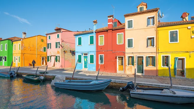 Colorful buildings line a waterfront with boats floating by the dock