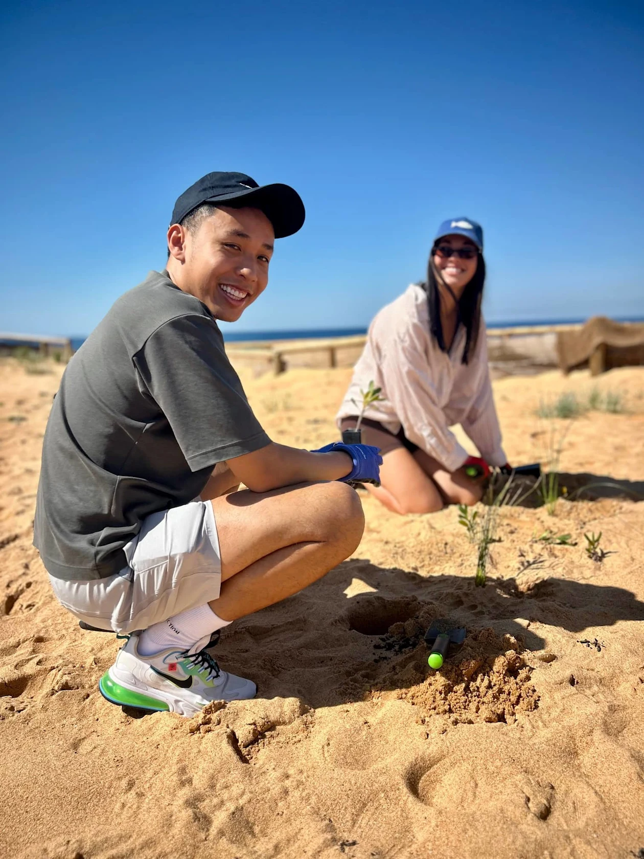 Pinterest employee and Impact Ambassador, Jamie Sayvong, and a colleague cleaning up the beach