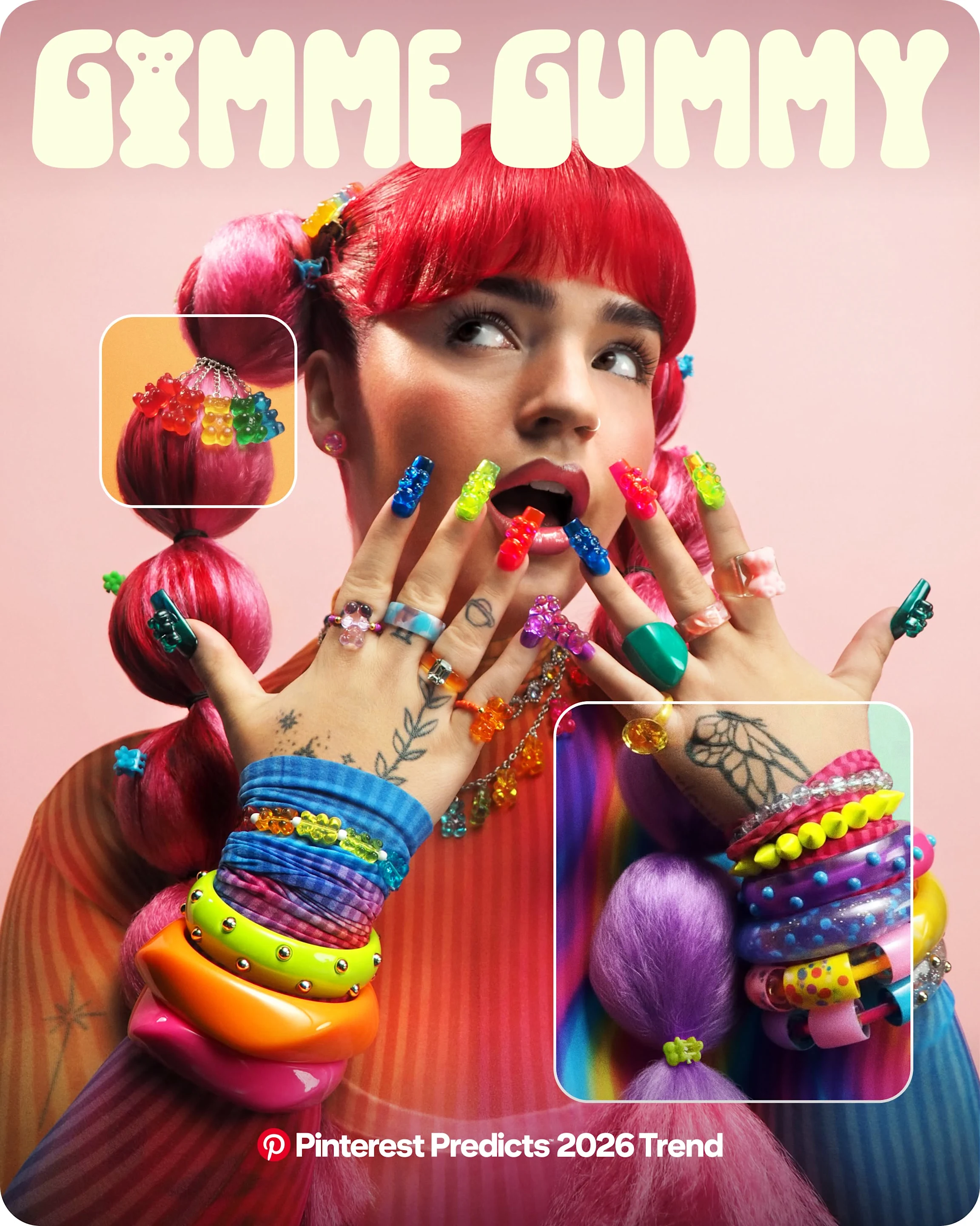 A young woman with pink pigtails wears bright, chunky accessories and has nails with plastic gummy bears stuck on them.