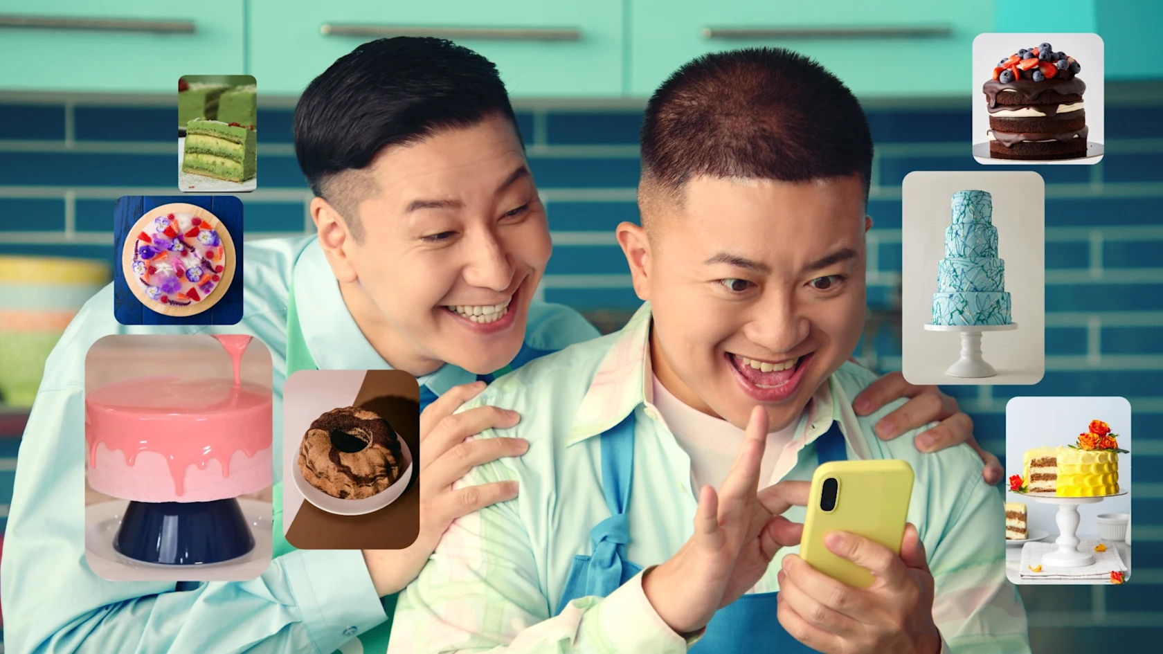 カラフルなキッチンで、男性 2 人が楽しそうにスマホの画面をスクロールしながら、きれいなケーキの画像を見ています