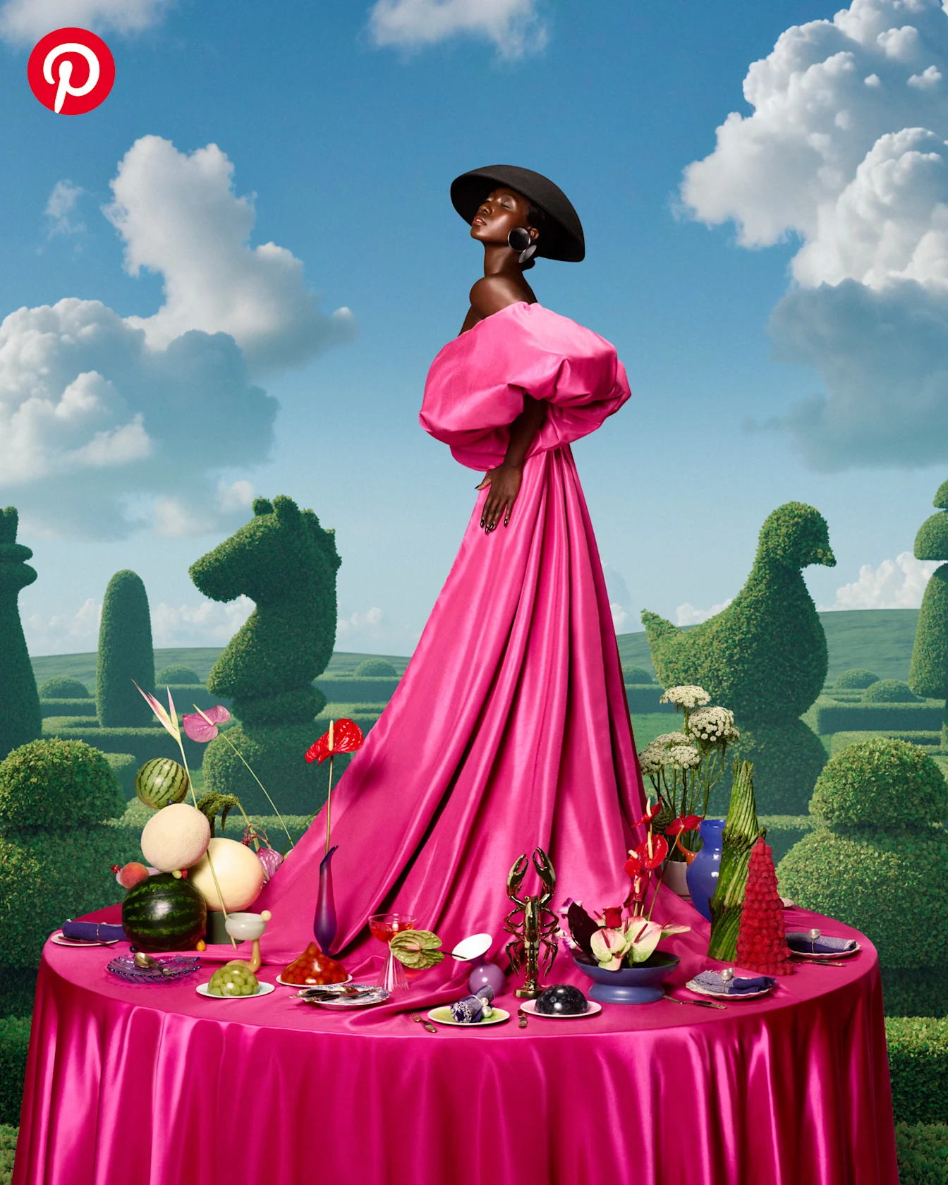 A woman in a hot pink ball gown standing on top of a brightly colored dinner party table
