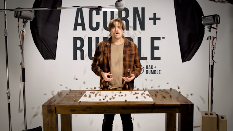 Producer Dave getting acorns poured on his head, in the video studio surrounded by light stands