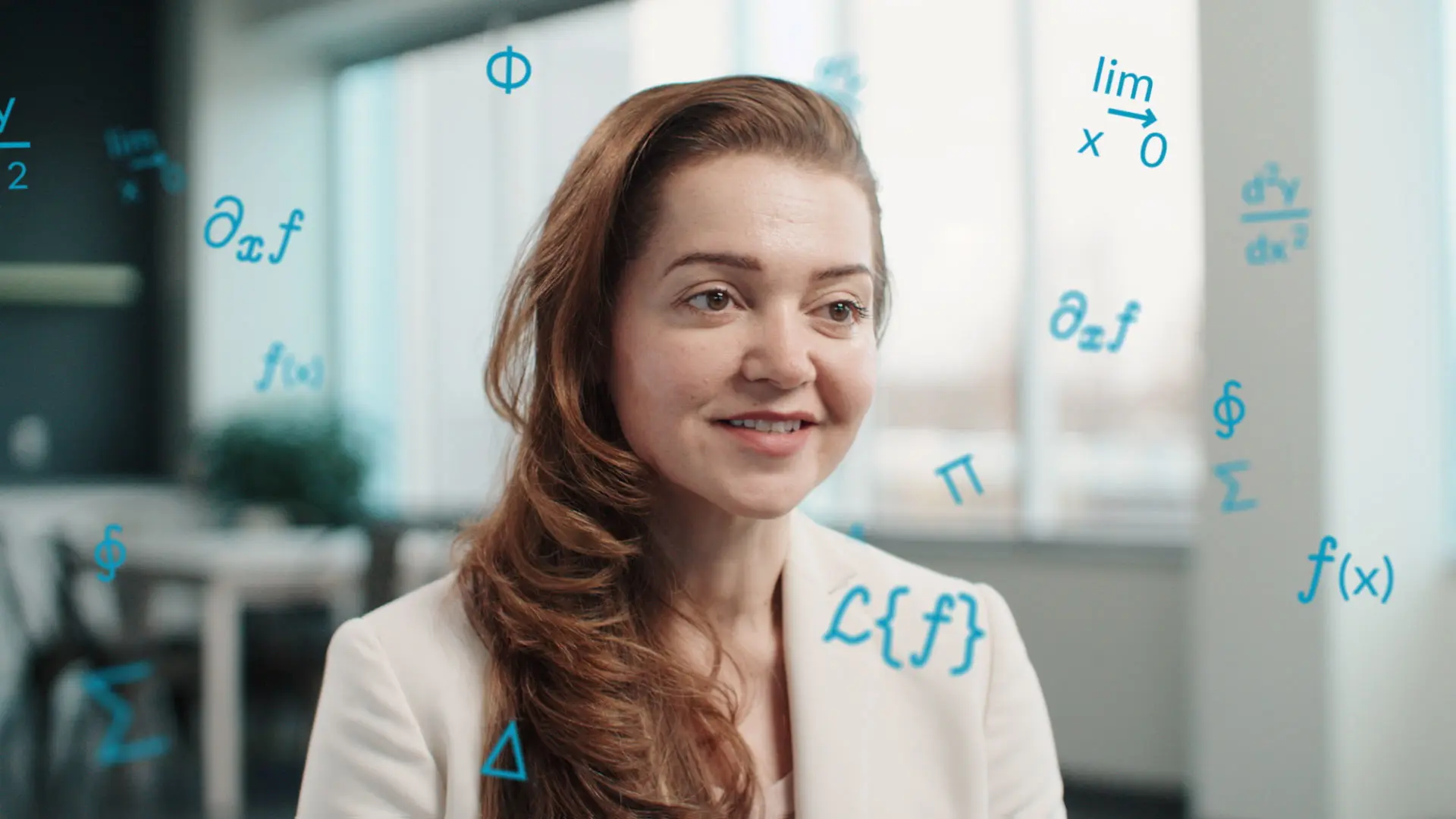 A DigitalEd leader speaks on camera while animated math symbols turn in the space beside them.