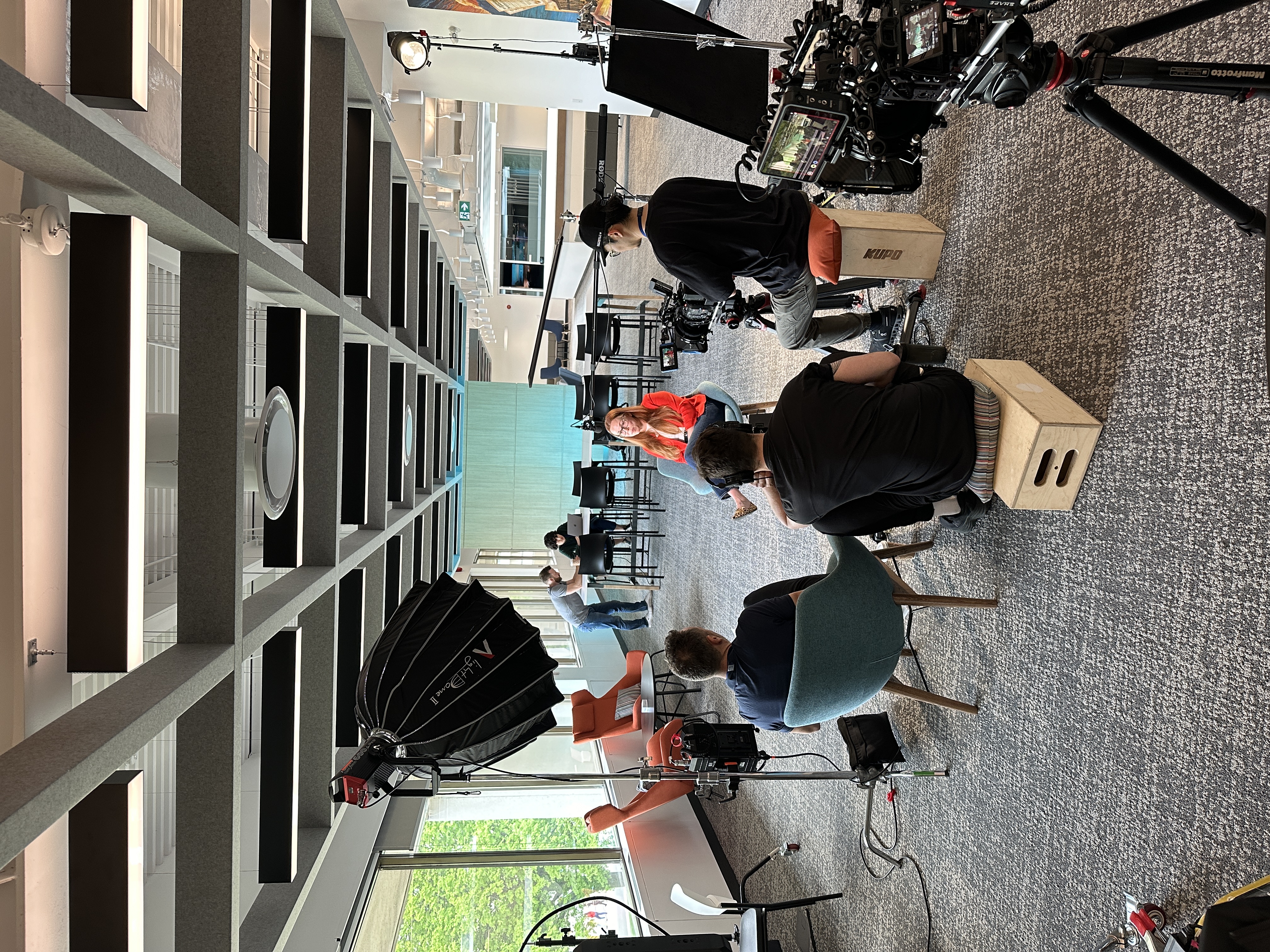 Crew filming an interview for Equitable's Moments Matter docuseries, with two cameras and lights set up in an office.