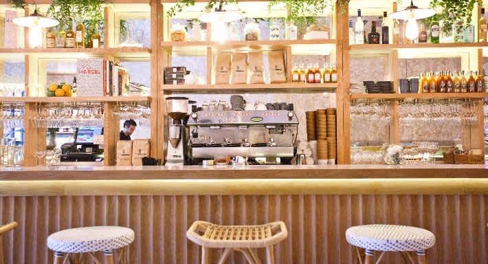 Interior photo of Merci Marcel in Singapore with bar seating and coffee machine at the counter 