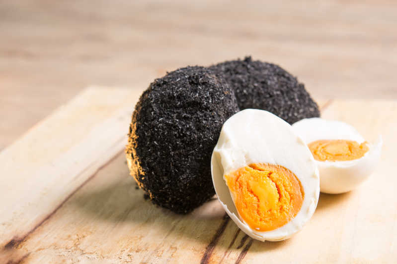 Close up of salted egg made the traditional way with a crust of black paste