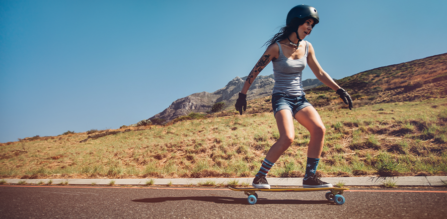Una mujer con un casco andando en skate