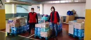 Dos hombres con máscaras y chalecos rojos de pie en un almacén