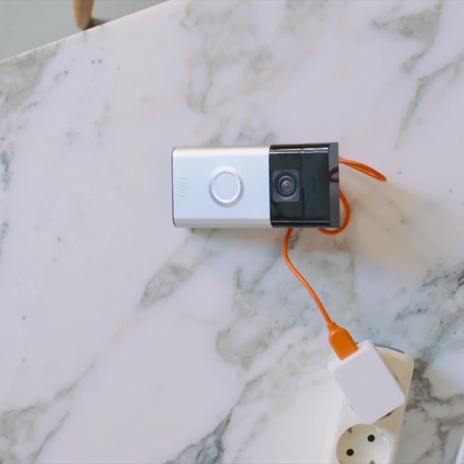 Video of older woman installing Ring Battery Video Doorbell next to a door and removing it for easy recharging.