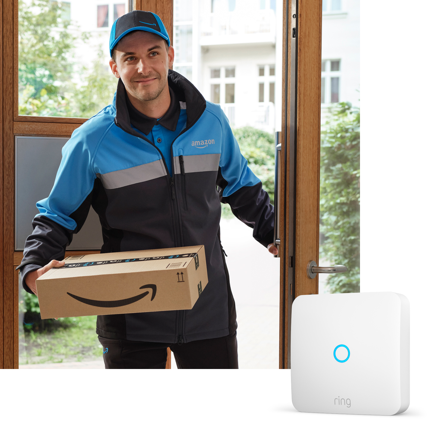 Amazon-Lieferfahrer betritt Gebäude mit Paket, Ring Intercom-Gerät in unterer Ecke sichtbar.