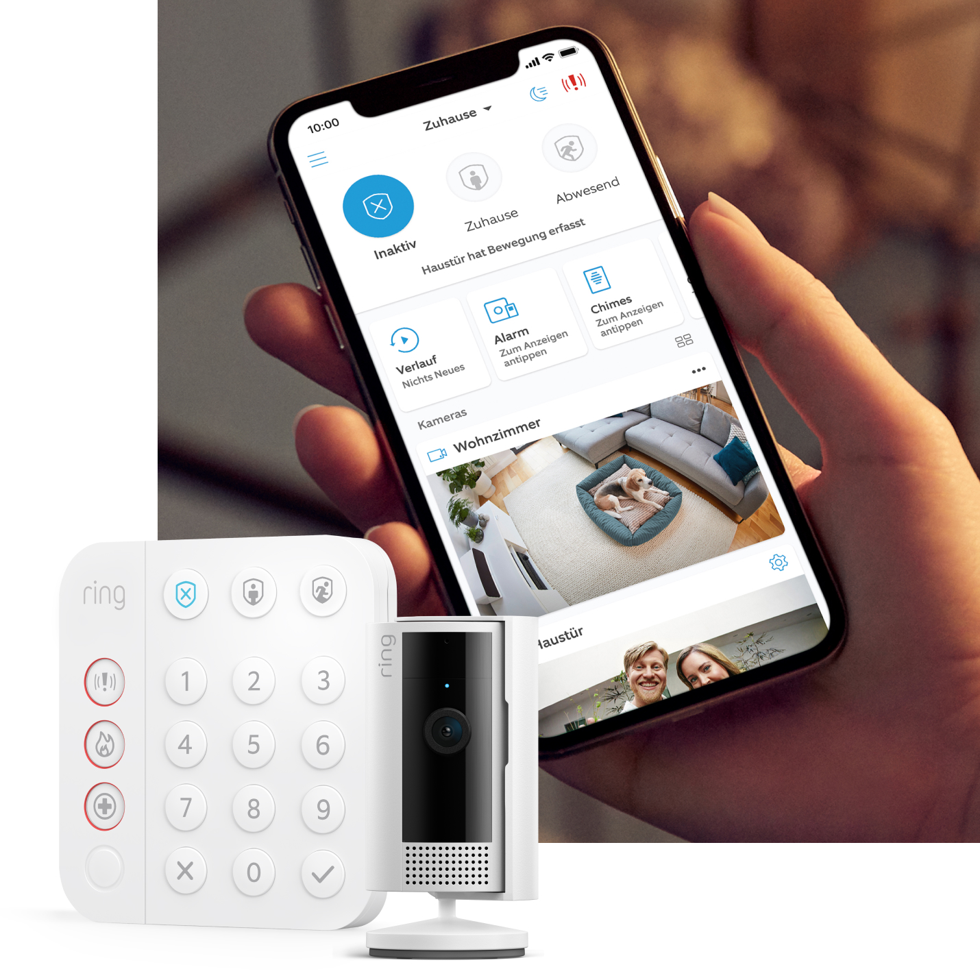 Ring Keypad und Indoor Camera neben Smartphone-Bildschirm mit Alarmstatus und Live-Ansicht des Haustiers im Wohnzimmer.
