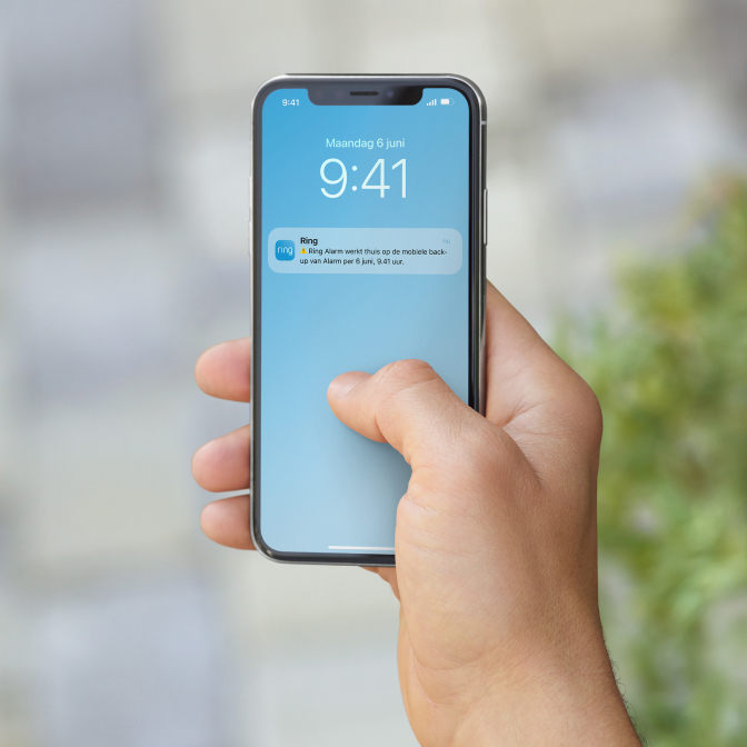 Smartphone toont Ring Alert over alarm op mobiele back-up, met tijd en datum.
