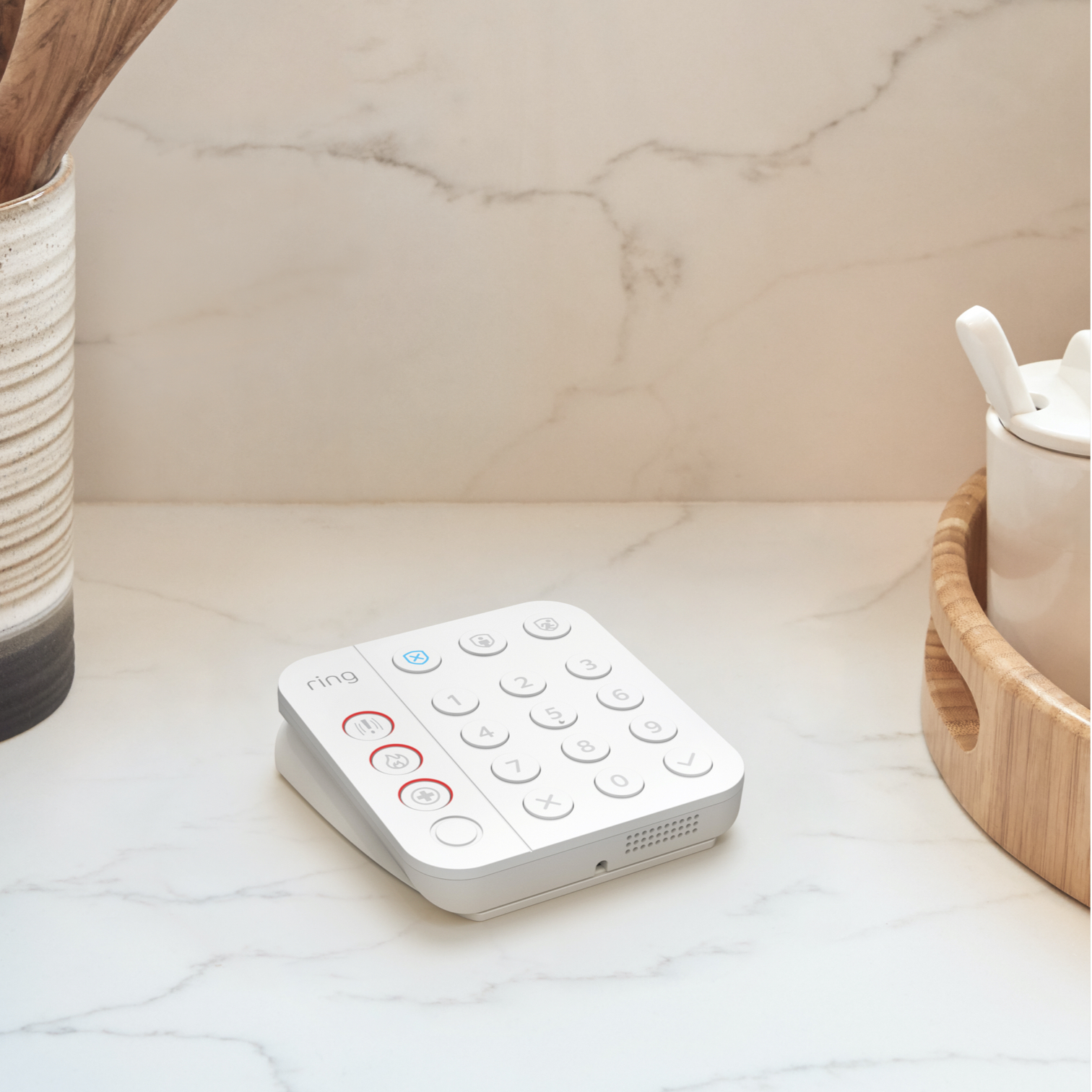 White Ring Alarm Keypad placed on marble surface, showing backlit buttons for arming, disarming, and emergency response.