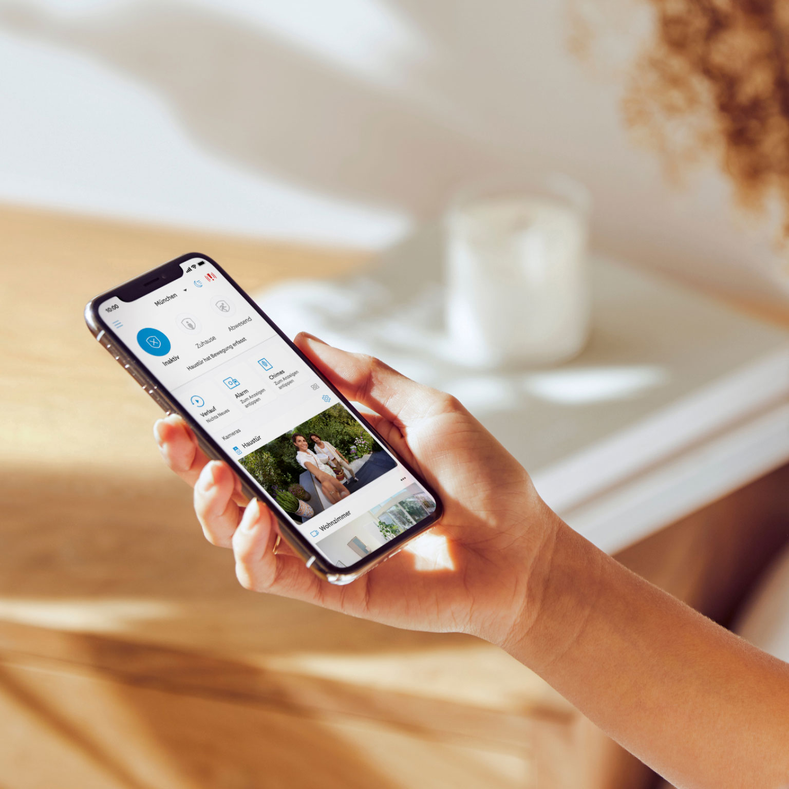Smartphone mit Ring-App-Oberfläche zeigt Live-Kamerabild, Datenschutz- und Sicherheitseinstellungen.