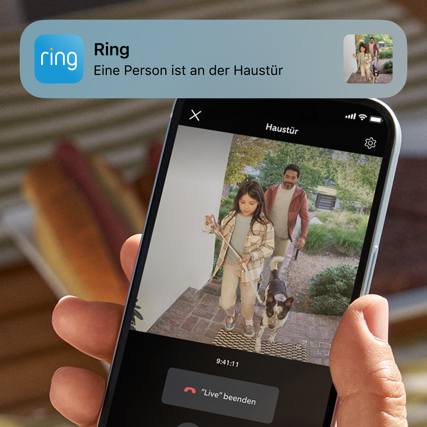 Smartphone zeigt Ring-Live-Video von Besuchern an der Haustür mit Bewegungsalarm und Anrufoptionen am Bildschirm.