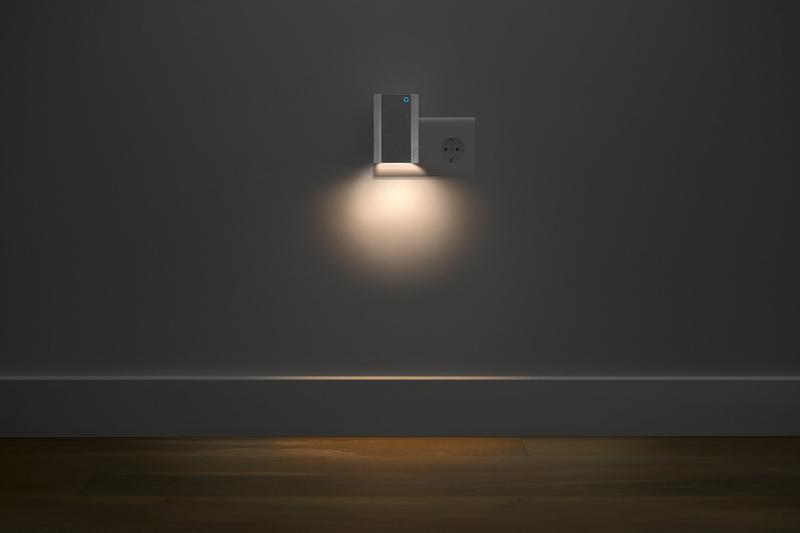 Ring Chime Pro plugged into wall socket, glowing nightlight softly illuminating dark room and wood floor.