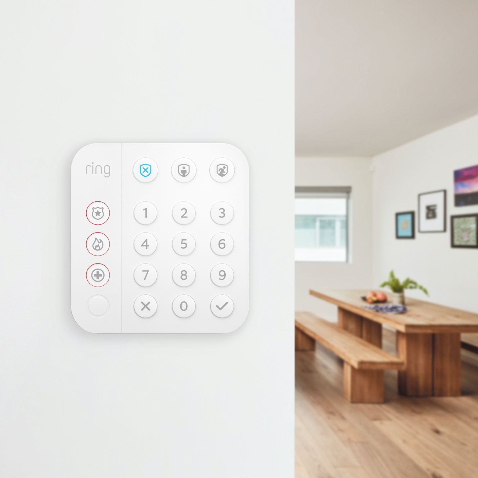 Ring Alarm Keypad mounted on a white interior wall, with a dining area visible in the background.
