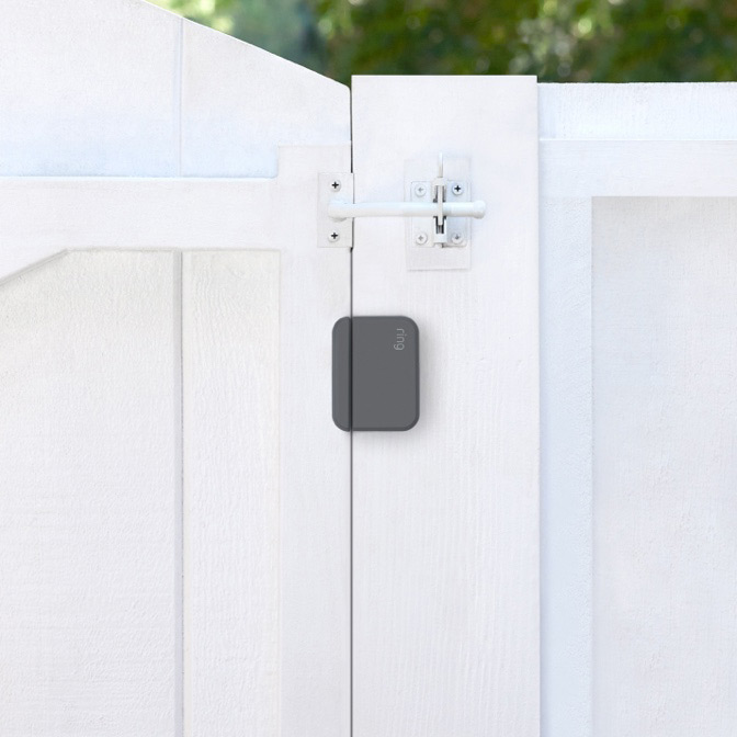 Ring Outdoor Contact Sensor mounted on white wooden gate to detect opening or tampering in outdoor environments.