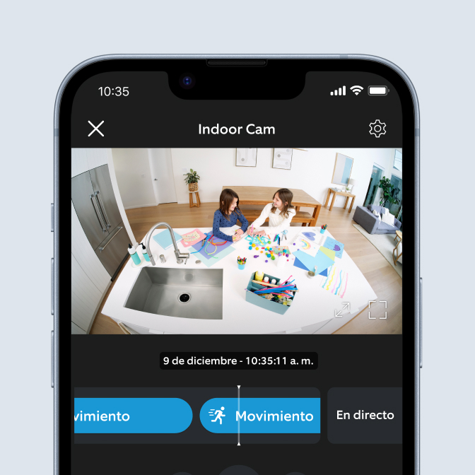Aplicación Ring en teléfono muestra Indoor Cam grabando a dos niños haciendo manualidades en la mesa a las 10:35