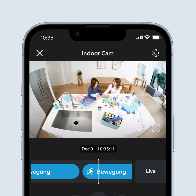 Ring-app op telefoon toont Indoor Cam-opname van twee kinderen die knutselen aan keukentafel op 9 dec om 10:35.