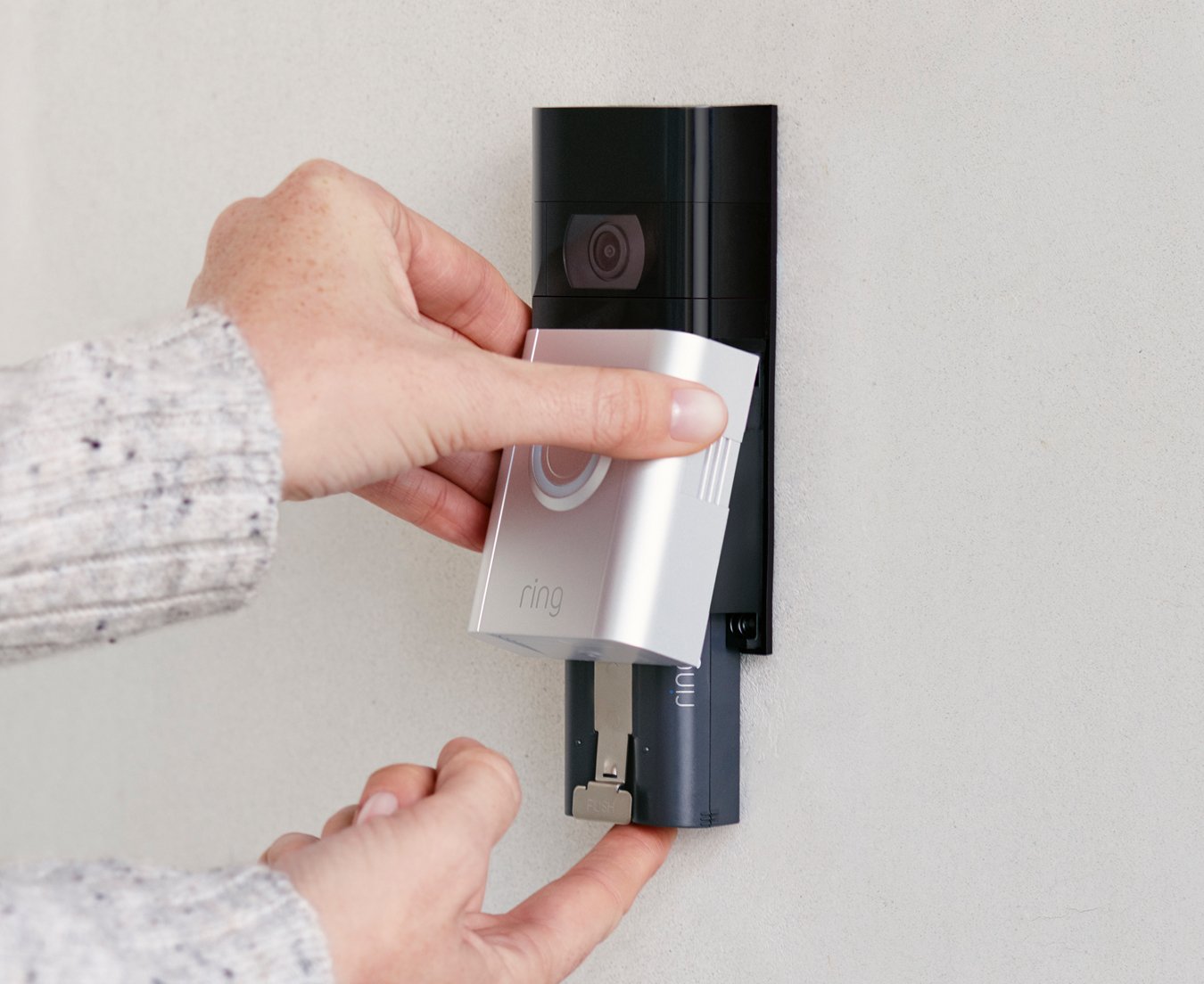 Person removing Ring doorbell Quick Release Battery Pack using quick-release tab for easy recharging.