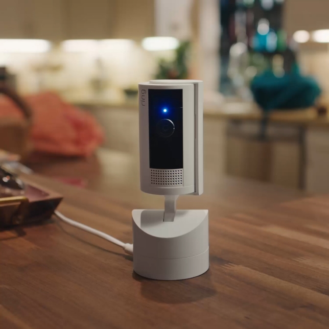 Hand slides Ring Indoor Camera privacy cover shut while app shows
