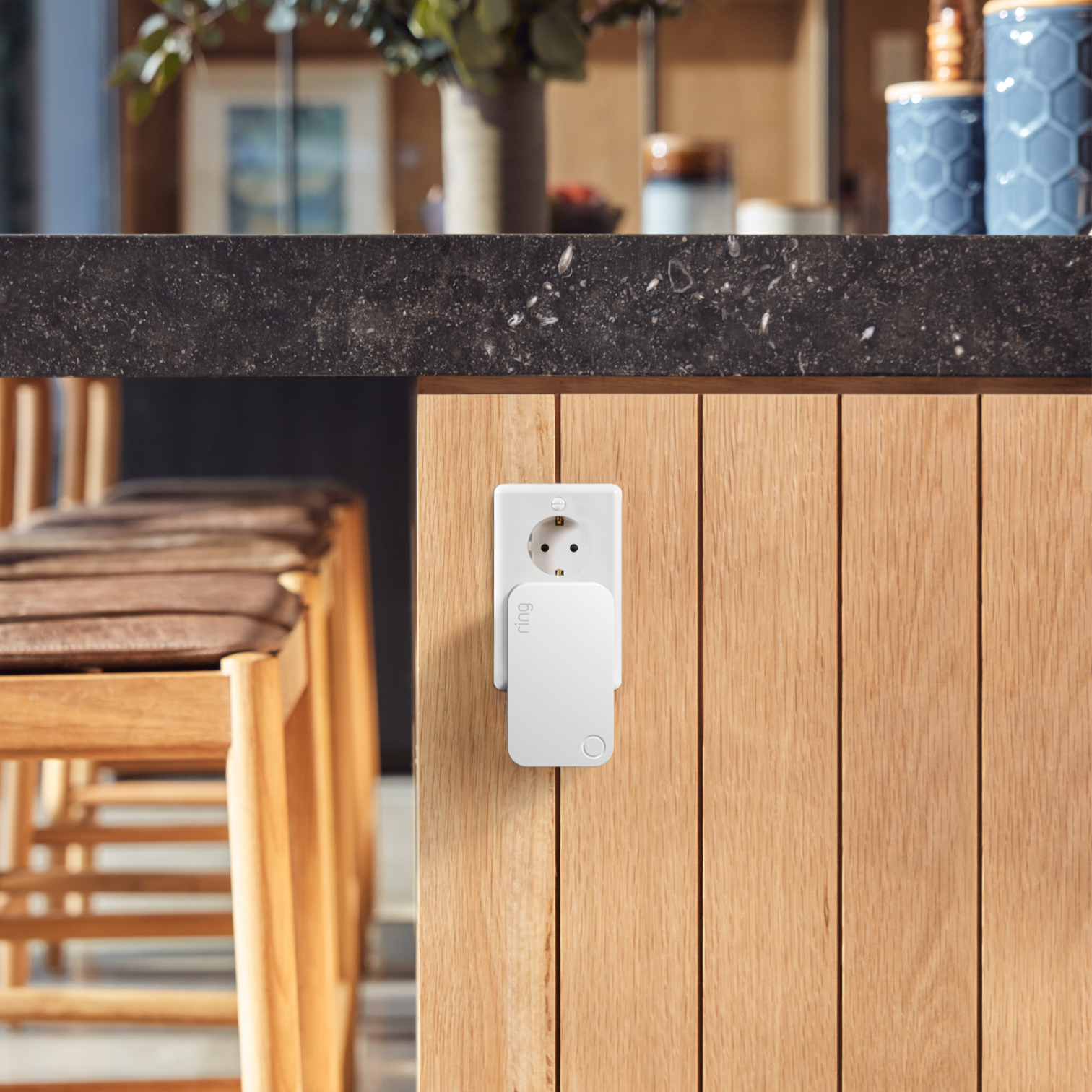 White Ring Range Extender plugged into wall socket below kitchen counter to boost Alarm system signal strength.