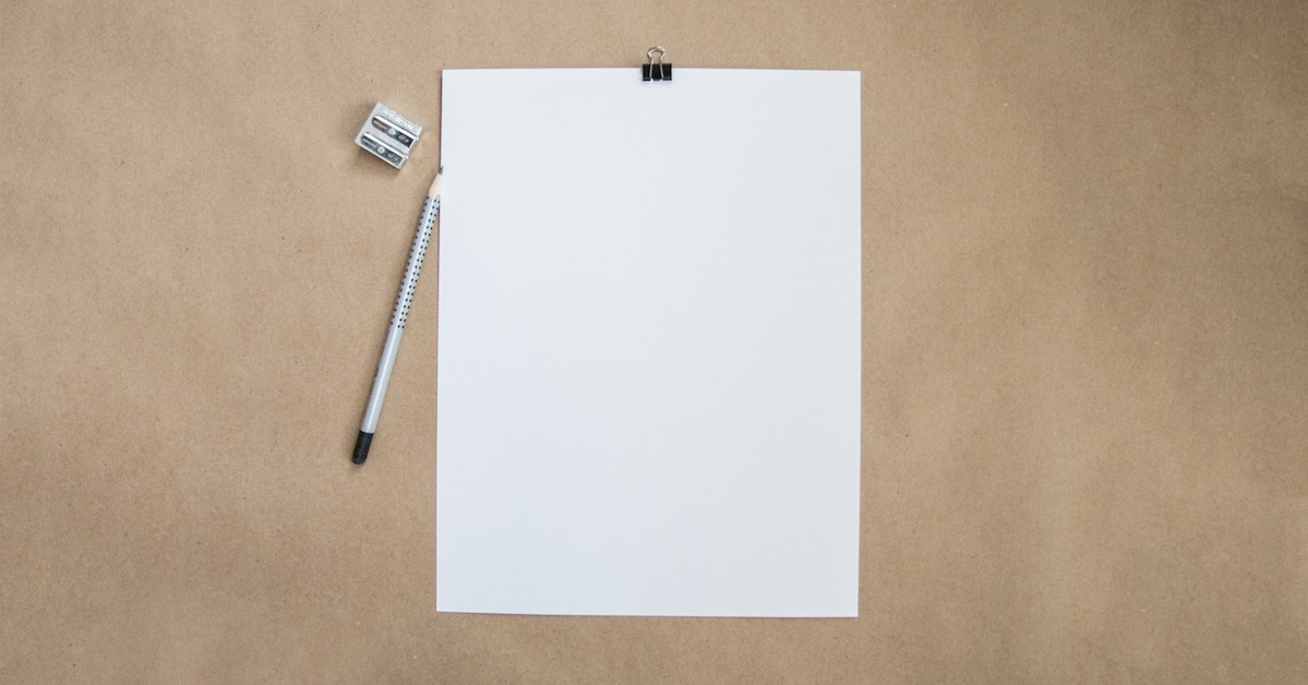 Papel em branco com lápis e apontador ao lado