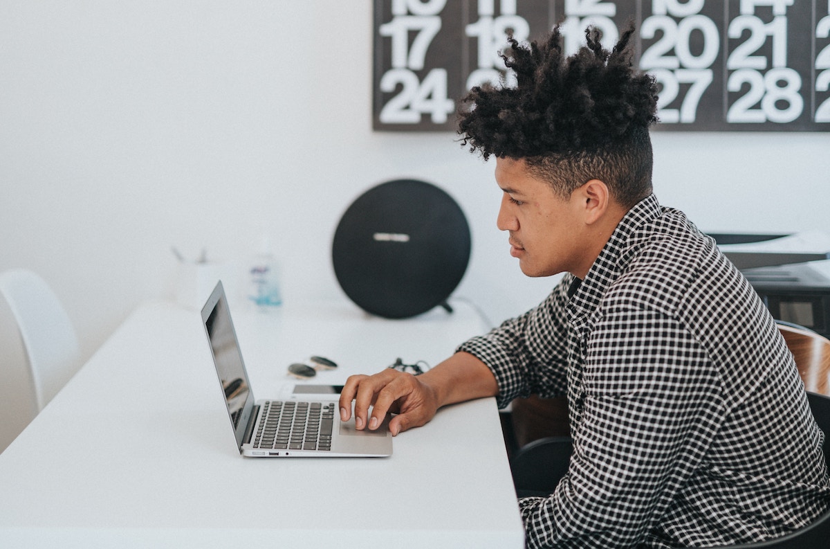 Homem jovem usando laptop em ambiente claro e informal