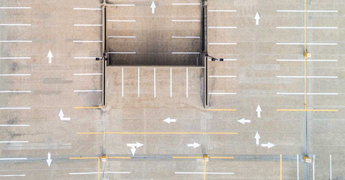 Visão aérea de estacionamento com setas em várias direções